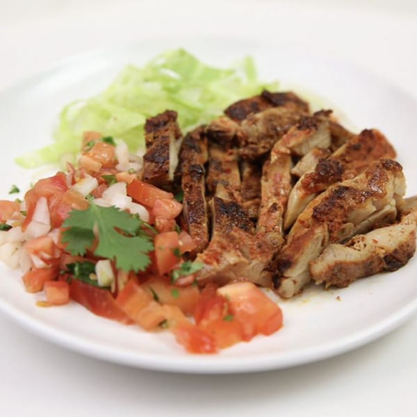 Alberto's Mexican Food's grilled chicken, pico de gallo, and shredded lettuce on a white plate.
